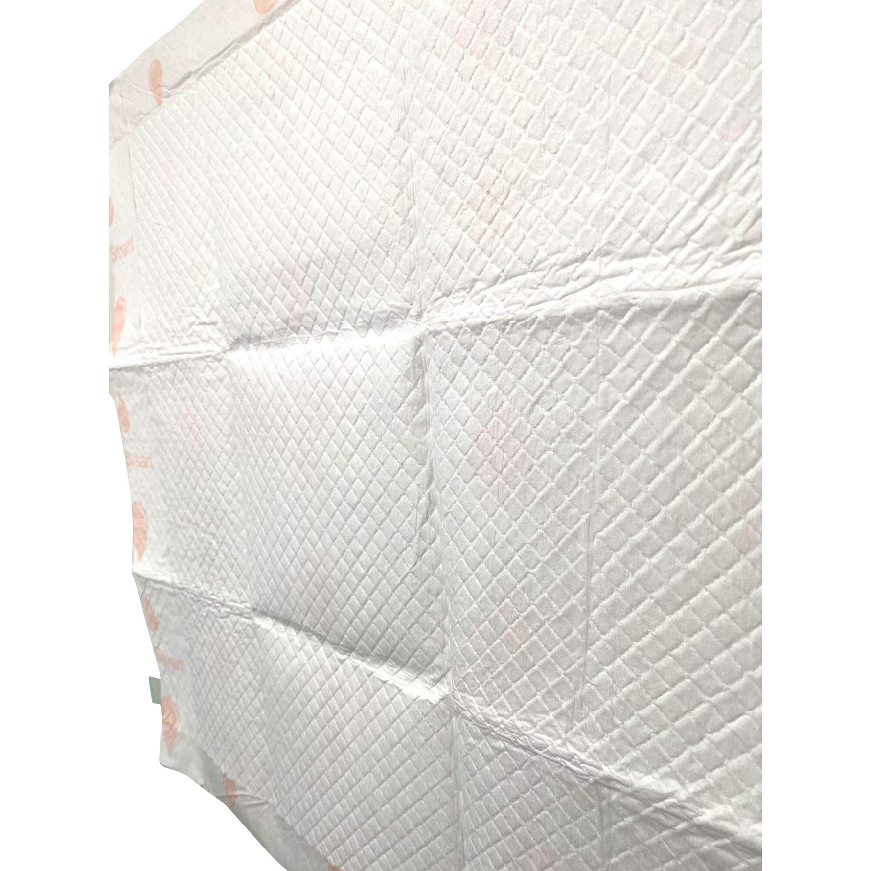 Folded stack of off-white puppy training pads with quilted texture and pink heart accents