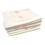 Stack of off-white dog training pads with small pink heart patterns on top layer
